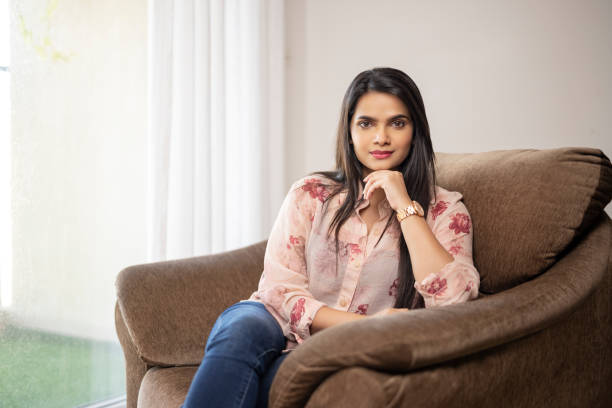 istock Pretty Indian young home relaxing on sofa at home. 1321755212