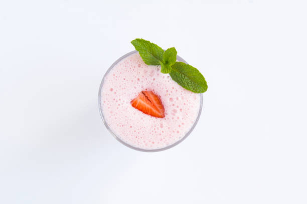 vue de dessus du milkshake à la fraise dans le verre à boire sur fond blanc - cocktail à la fraise photos et images de collection
