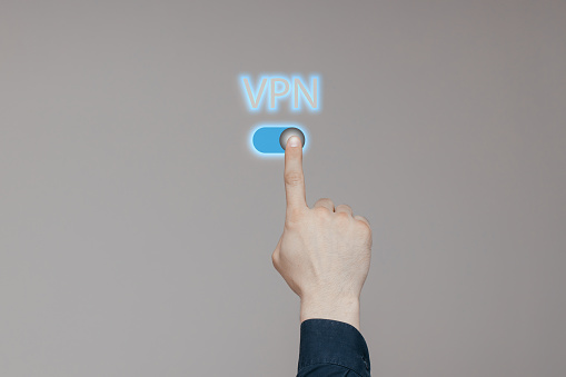 Businessman's hand manually presses the button on the VPN. Concept of private network security. High quality photo