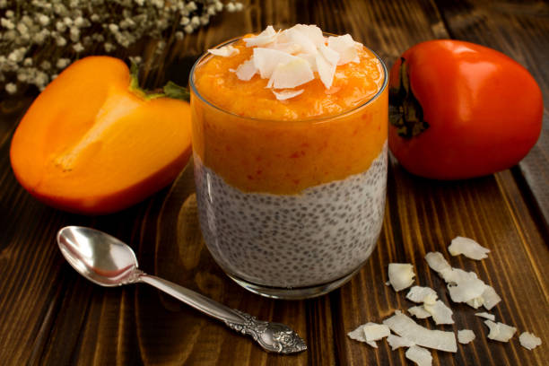 istock Pudding with chia seed, persimmon and coconut chip on the brown  wooden background 1321757288