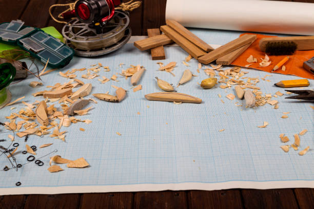 istock Handmade wooden fishing tacles graph paper background with tools and blanks. 1321757554