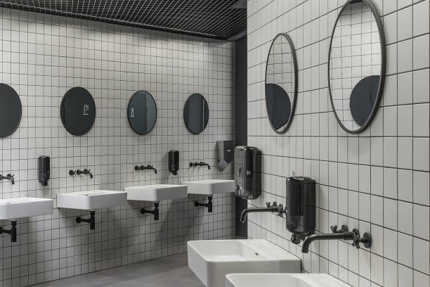istock Modern public restroom minimal interior with metro style white tiles, round mirrors, black ceiling 1321757638