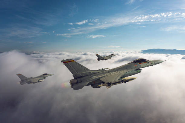 istock Jet fighters flying over the clouds. 1321771591