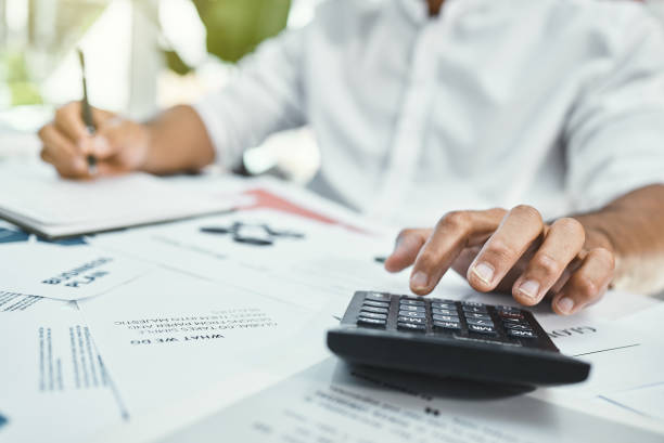 istock Cropped shot of an unrecognizable businessman using his calculator while working on paperwork 1321777780