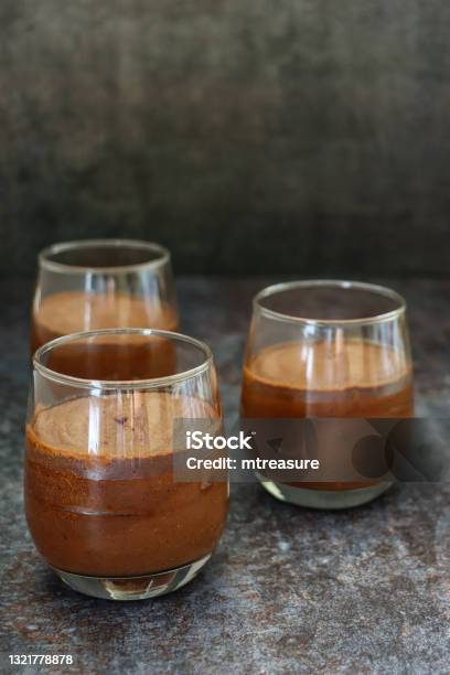 Image Of Three Glasses Containing Homemade Chocolate Mousse Dessert Dark Grey Background Focus On Foreground Stock Photo - Download Image Now