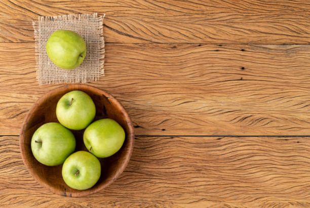istock Green apples in a bowl over wooden table with copy space 1321779023