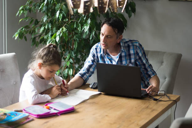 istock Father helping his daughter about education at home 1321783217