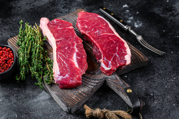 istock Raw marbled beef meat sirloin steak. Black background. Top view 1321784238