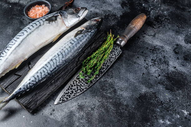 istock Raw fish Mackerel on a wooden cutting board. Black background. Top view. Copy space 1321784255