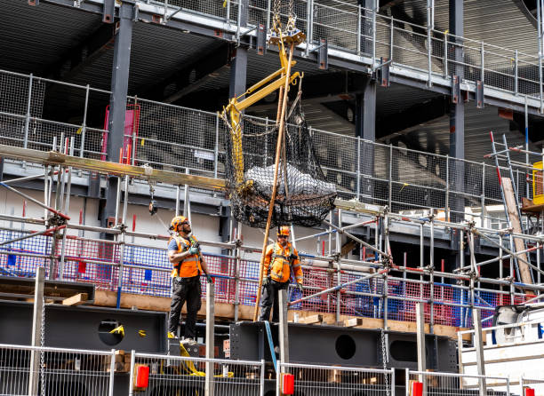 teamarbeit unter bauherren, die geräte per kran bewegen - urban growth audio stock-fotos und bilder