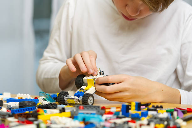 istock Close up of child's hands playing with colorful plastic bricks at the table. development of fine motor skills in children, favorable for the development of brain activity. Developing toys 1321787828