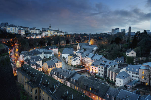 Luxembourg city skyline at night - Aerial view of The Grund with St Michaels Church on background - Luxembourg City, Luxembourg Luxembourg city skyline at night - Aerial view of The Grund with St Michaels Church on background - Luxembourg City, Luxembourg luxemburg stock pictures, royalty-free photos & images
