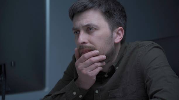 istock Tired male working on computer. Sad exhausted man at home office. Stressful work, stress at workplace. Software developer looks very tired during completion overtime of project, working on computer 1321794200