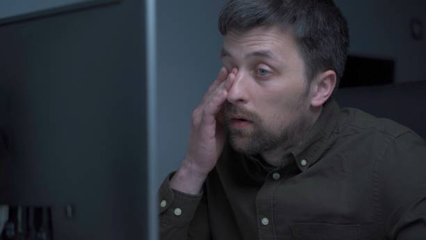 istock Tired male working on computer. Sad exhausted man at home office. Stressful work, stress at workplace. Software developer looks very tired during completion overtime of project, working on computer 1321794260