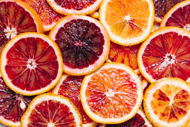 Bright colorful background of fresh ripe sliced blood oranges. Close up, flat lay. stock photo