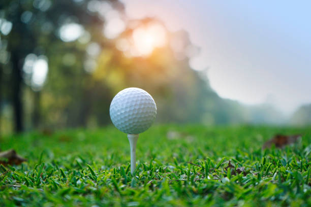 istock Golf ball on tee in beautiful golf course at sunset background. 1321828131