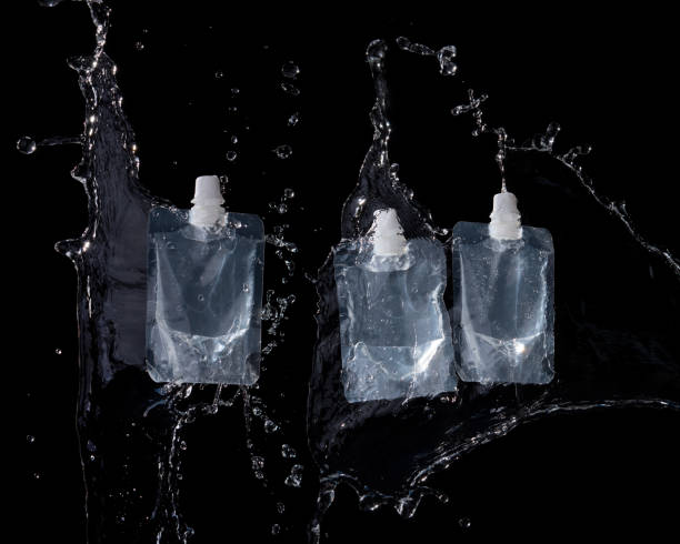 istock Transparent  plastic package for water or gel with water splash on a black background 1321839119