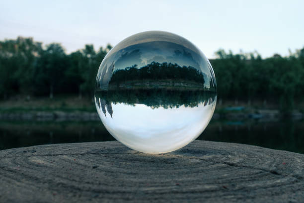 istock Crystals glass ball reflect riverbank on a tree trunk 1321840385