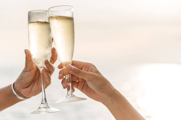 istock Hand holding a glass drinking wine on Sunset sea background. 1321844521