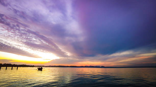 日没時の湖での伝統的な漁船のシルエット - lake victoria ストックフォトと画像