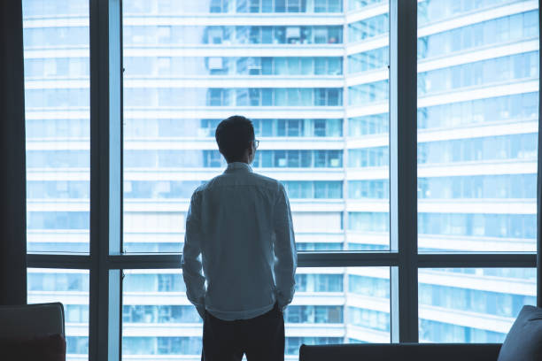 istock Businessman looking through window in office 1321851018