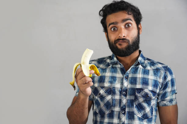 istock man eating banana and shocked by knowing his benefits 1321851174