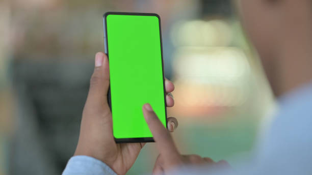 istock Rear View of African Man using Smartphone with Chroma Screen 1321864933