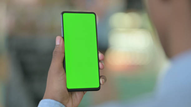 istock African Man Holding Smartphone with Green Chroma Screen 1321864942