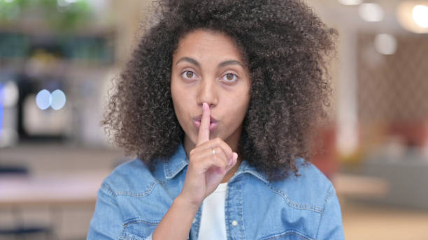istock African Woman Putting Finger on Lips, Quiet Sign 1321867164