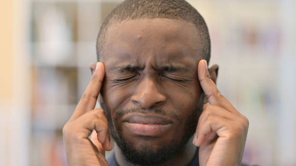 istock Close up of Exhausted Young African Man having Headache 1321867199