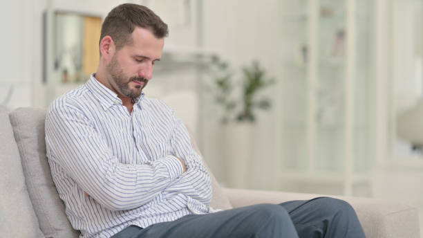 istock Exhausted Young Man Taking Nap on Sofa at Home 1321868572