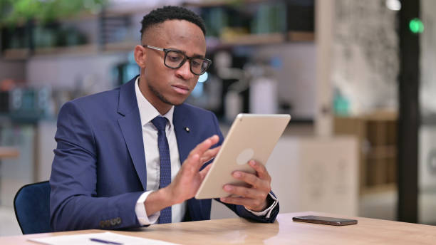 istock Serious Professional Young African Businessman using Tablet in Office 1321868592