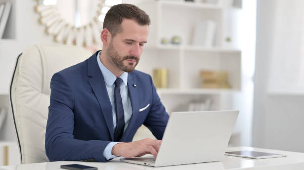 istock Serious Businessman using Laptop in Office 1321868720
