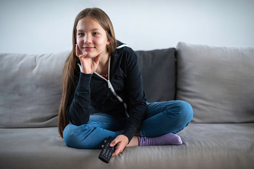 A girl watching TV at home
