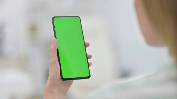 istock Woman Holding Smartphone with Green Key Chroma Screen 1321871694
