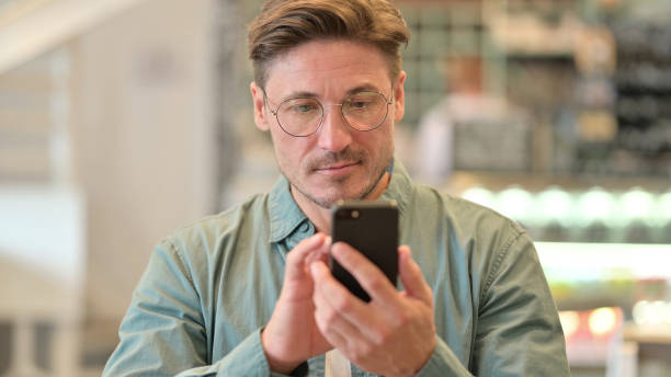 istock Portrait of Attractive Middle Aged Man using Smartphone 1321872217