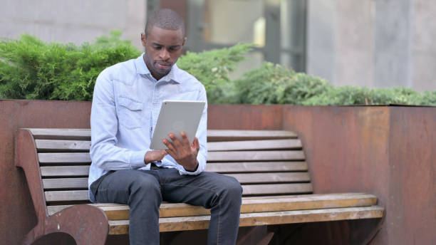 istock Professional Young African Man Using Tablet Outdoor 1321873215