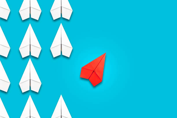 istock Red paper plane flying in a different direction than the white ones. Blue background. Copy space. The concept of innovative solutions, creativity. Business. Lifestyle. 1321875200