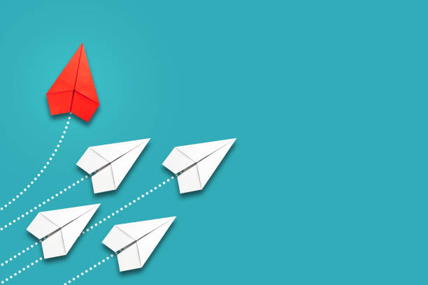 istock Red paper plane flying in a different direction than the white ones. Blue background. Copy space. The concept of innovative solutions, creativity. Business. Lifestyle. 1321875201