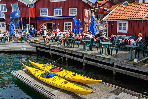 Fjällbacka, Sweden - July 14, 2015: People at a restaurant in the harbor of Fjallbacka in Sweden