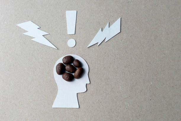The effects of caffeine on the brain image from coffee beans, cardboard and white paper stock photo