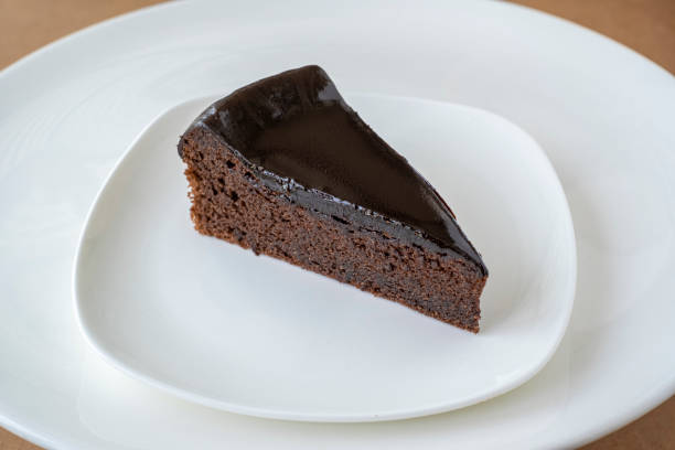 istock Slice of chocolate cake on white plate 1321879937