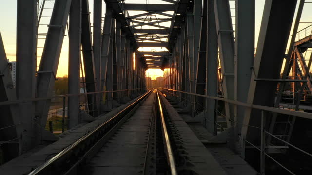 Railway bridge at sunset, flights to the horizon at dawn.