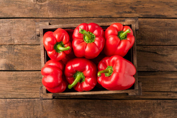 toma de pimiento rojo en caja sobre mesa de madera vintage con copyspace. pimentón dulce - pepper bell pepper growth ripe fotografías e imágenes de stock