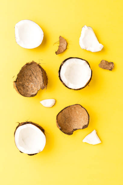 istock Fresh cracked coconut on yellow background. Flat lay 1321882072