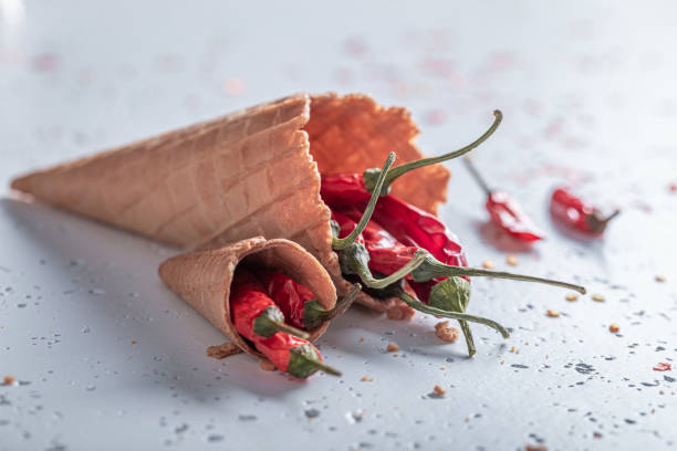 istock Spicy ice cream. Chilli peppers in ice cream cone. 1321882306