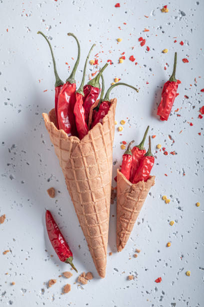 istock Spicy ice cream. Ice cream cone and chilli peppers. 1321882328