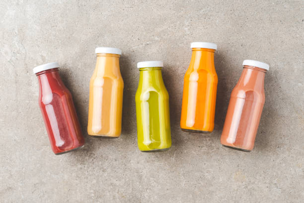 istock Colourful juices on stone table. Fresh smoothies in bottles 1321882489