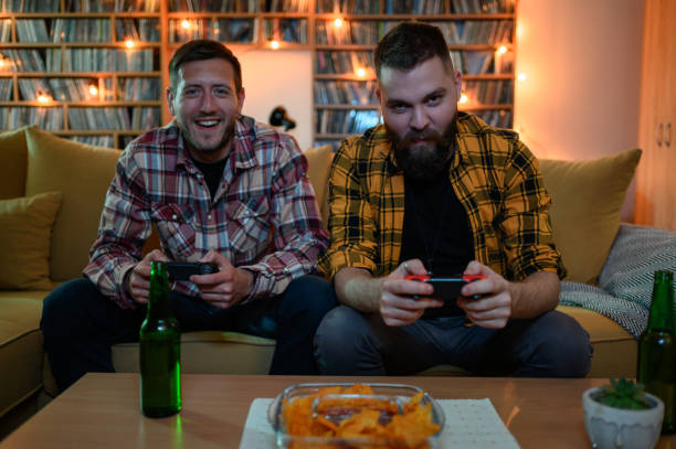 istock Two best friends playing video games while relaxing at home 1321884072