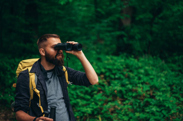 istock A hiker man walking in the forest using trekking poles and binoculars 1321884085